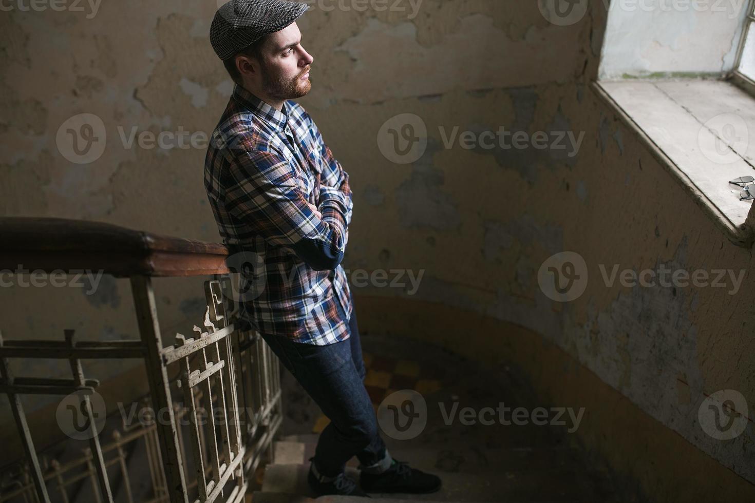 l'uomo con gli stivali autentici e i jeans a cimosa sullo sfondo della città vecchia foto