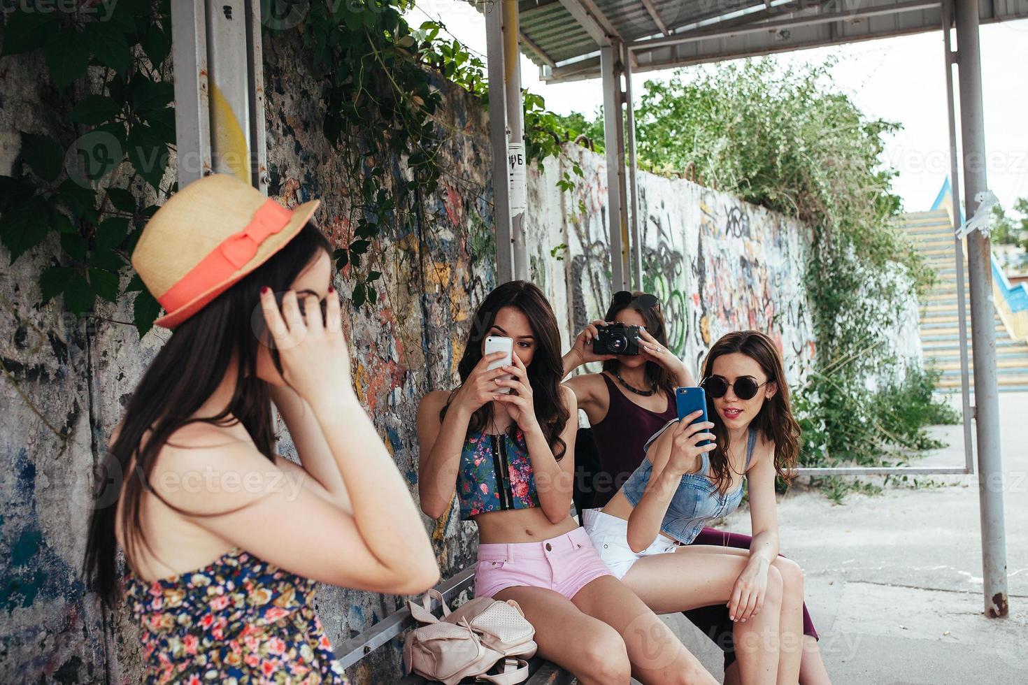 quattro bellissimo ragazze a il autobus fermare foto