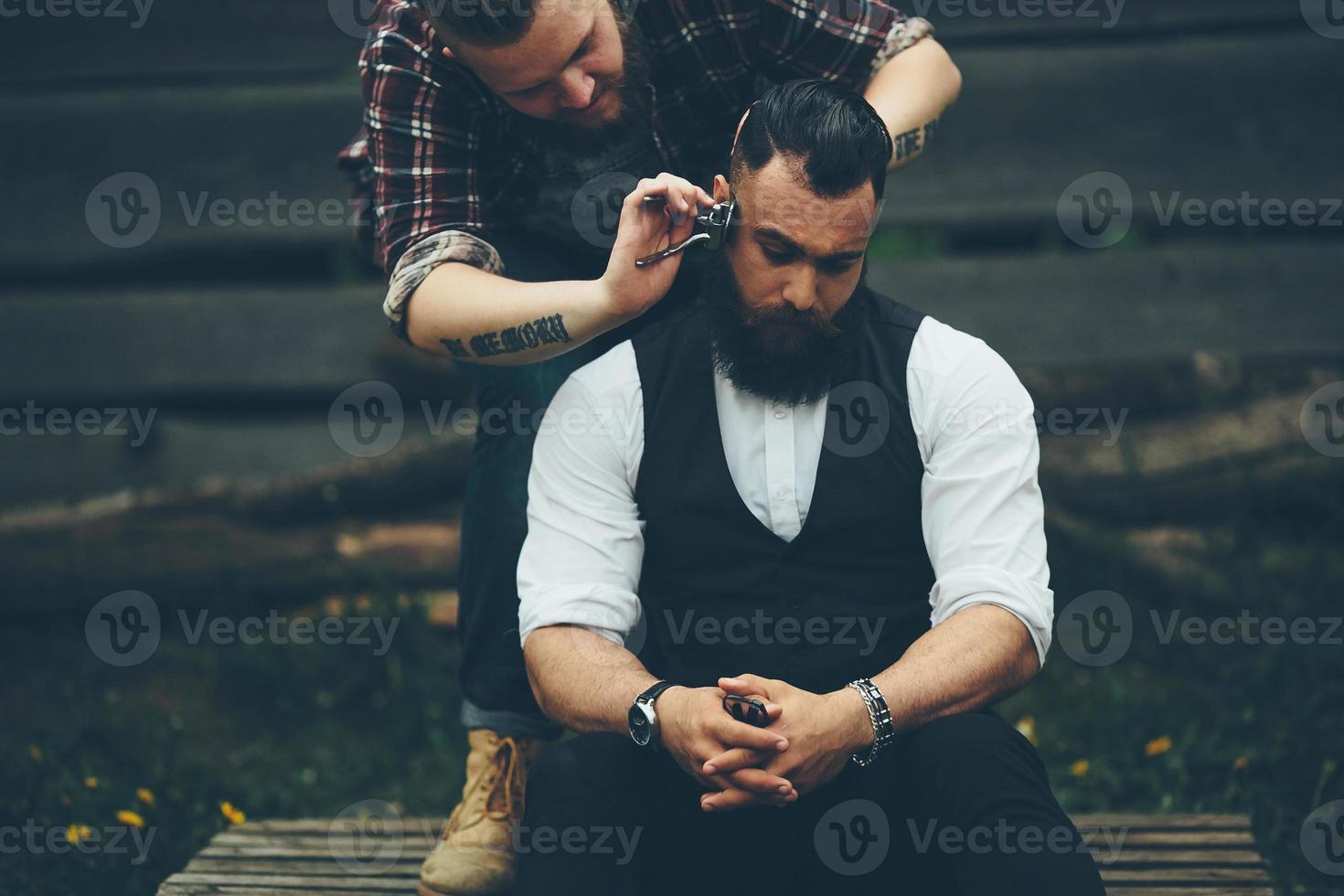 il barbiere rade un uomo barbuto foto