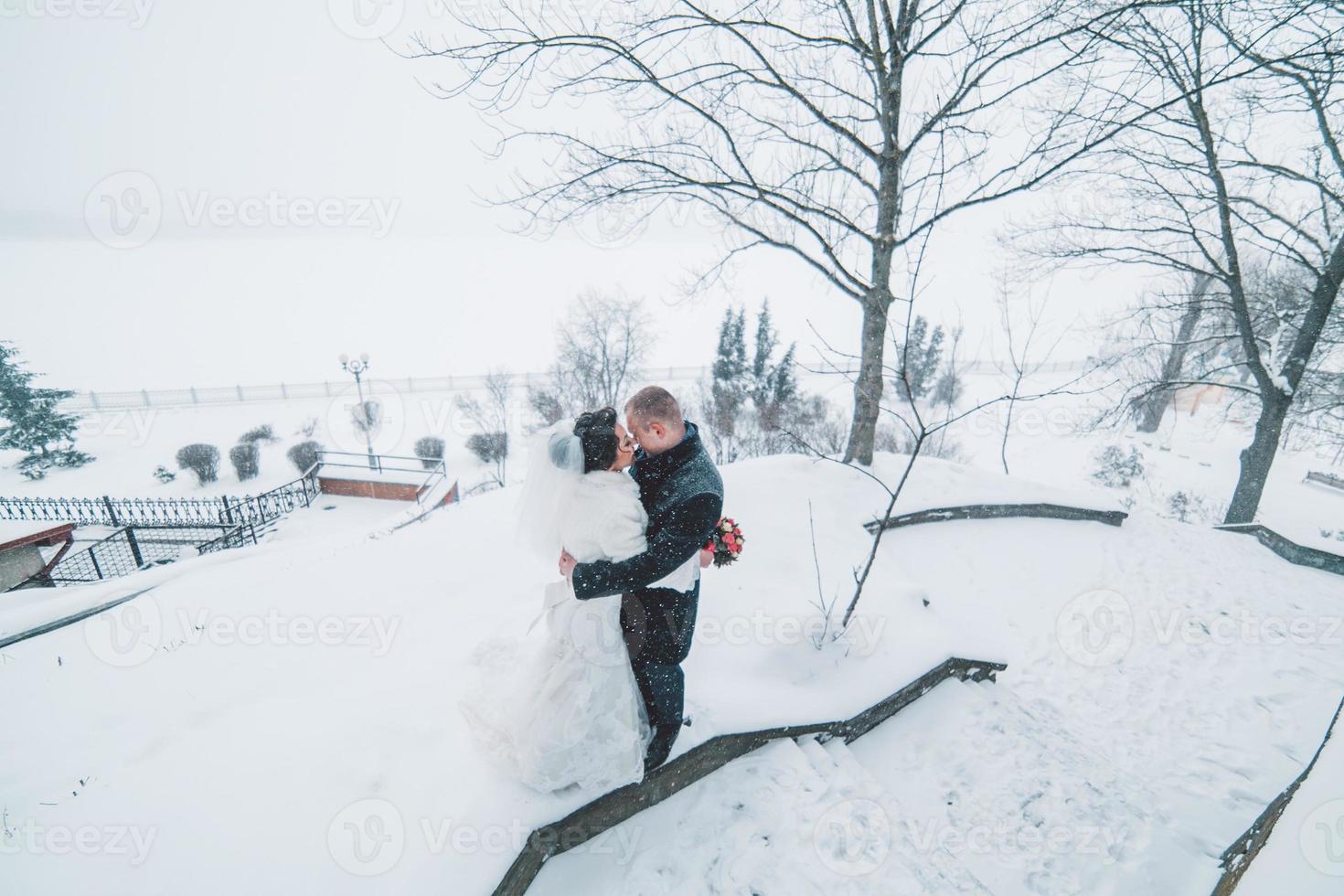 sposa e sposo che camminano sulla città europea nella neve foto