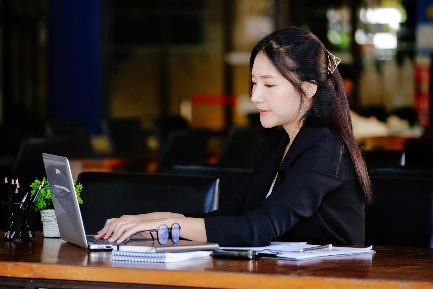 il concetto di un' attività commerciale donna utilizzando un' computer per dai un'occhiata finanziario dichiarazioni e investimenti attraverso il Internet. foto