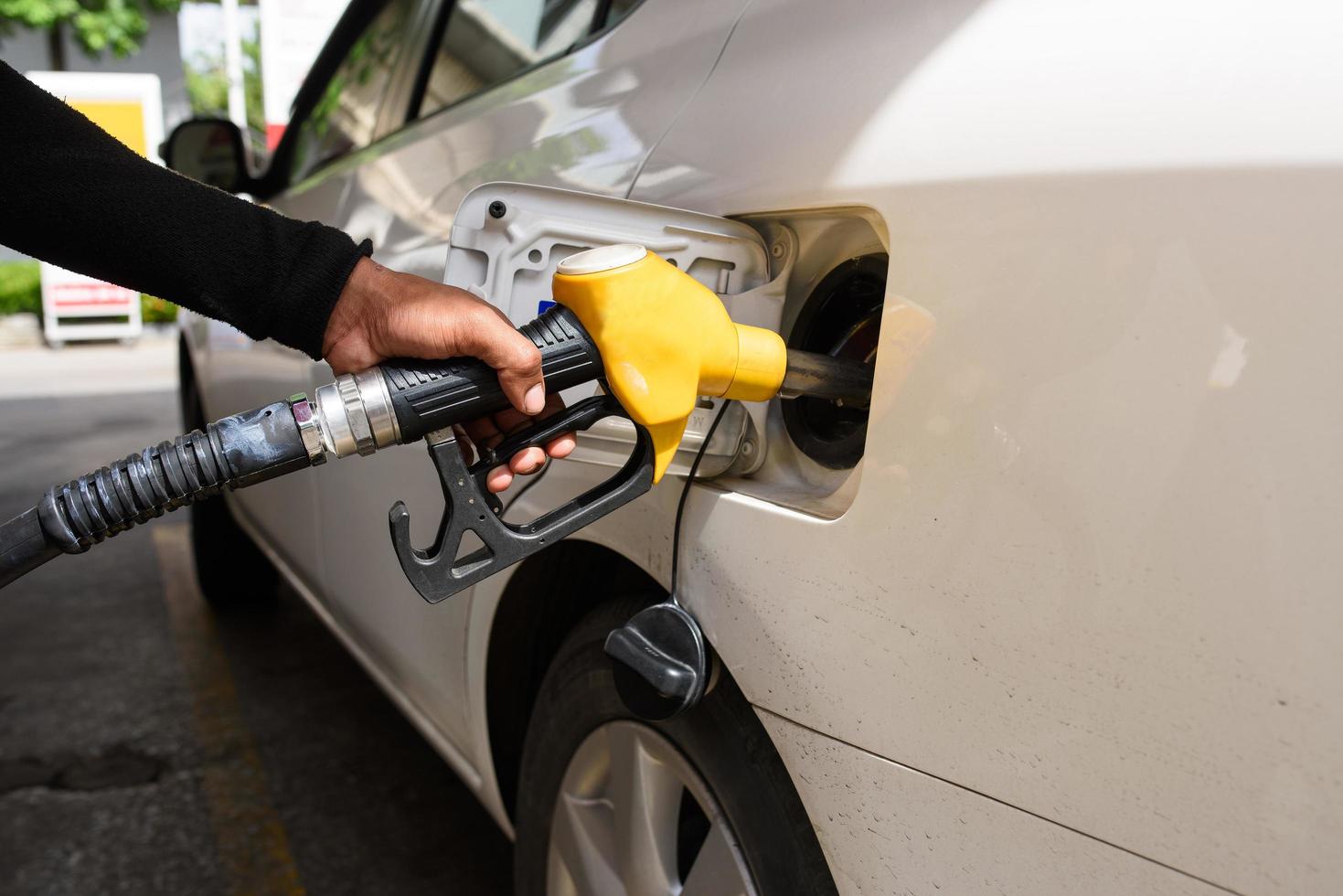 mano ricarica la macchina con carburante, messa a fuoco a mano foto