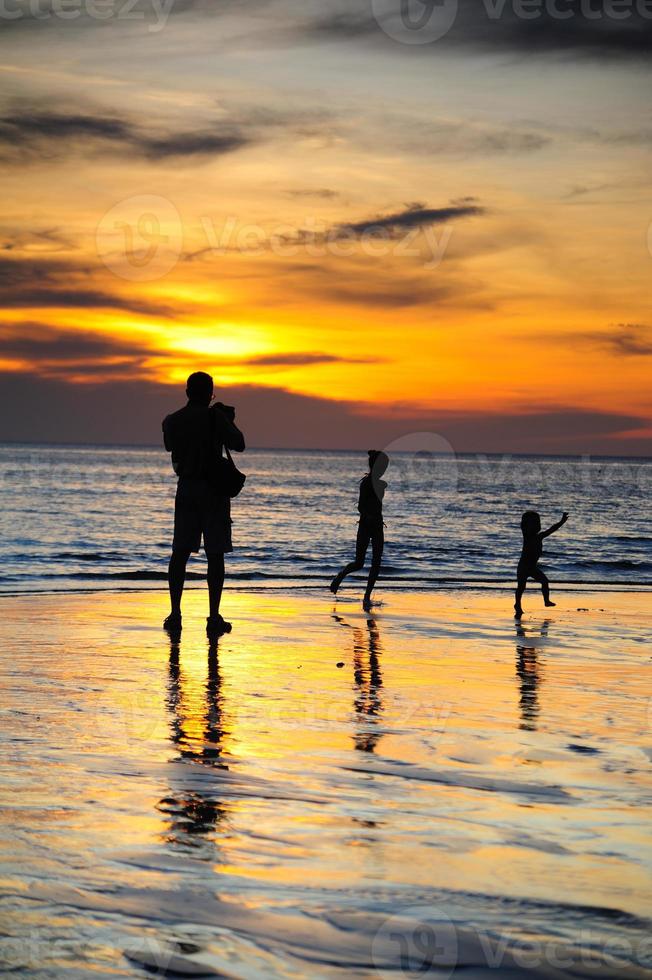 silhouette di Due adulti e un' bambino a il costa foto