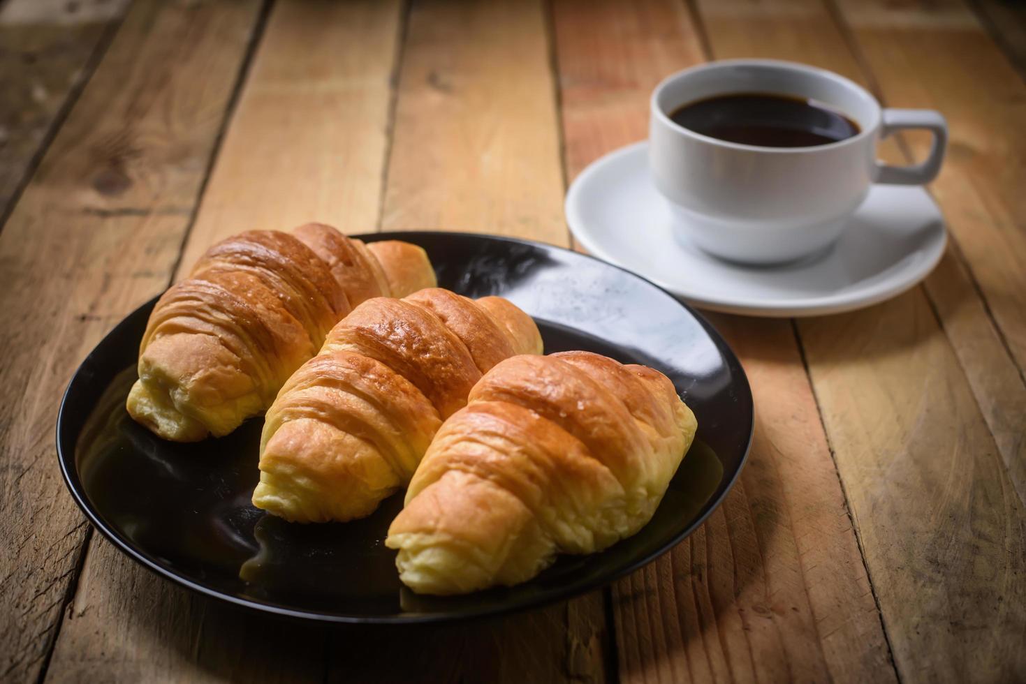 delizioso Cornetti su piatto e caffè tazza foto