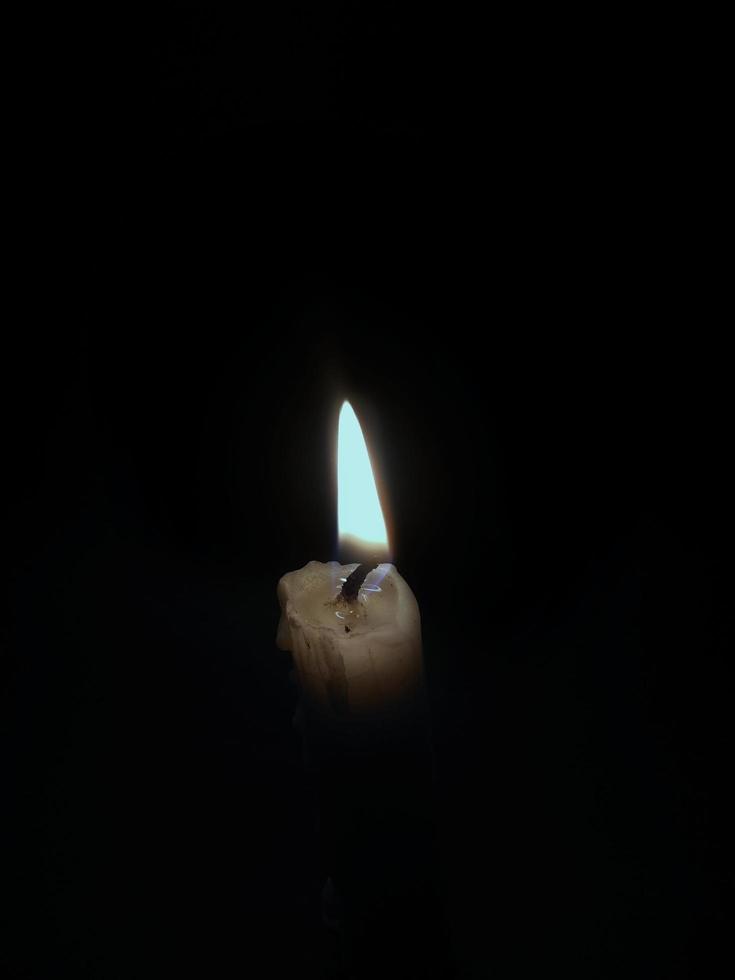 un' piccolo candela ardente nel un' intonazione buio atmosfera foto