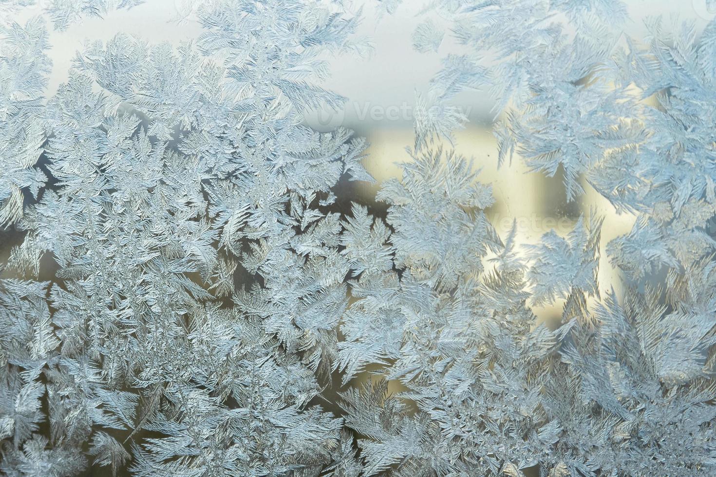 finestra invernale congelata con struttura a motivo ghiaccio brillante. simbolo di meraviglia di natale, sfondo astratto. temperatura bassa estrema del nord, neve ghiacciata naturale su vetro gelido, clima invernale fresco all'aperto. foto