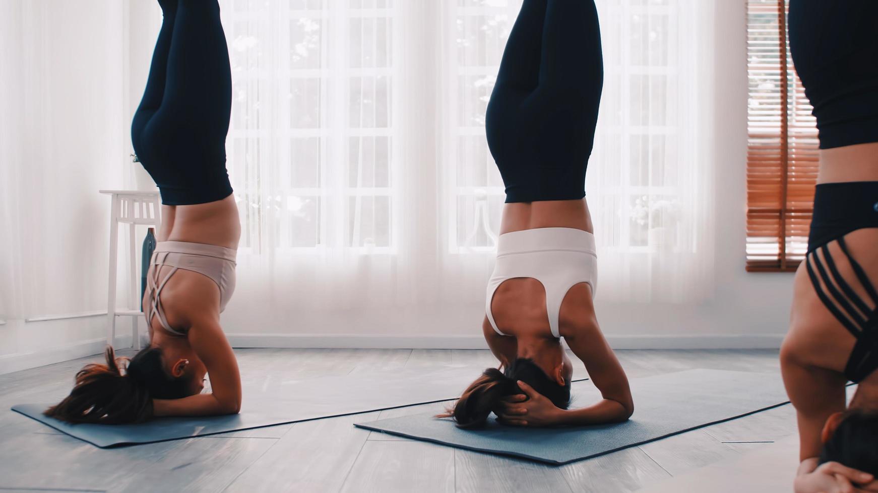 gruppo di asiatico donne allungamento nel yoga classe. gruppo di ragazze fare pilates esercizi a il palestra. foto