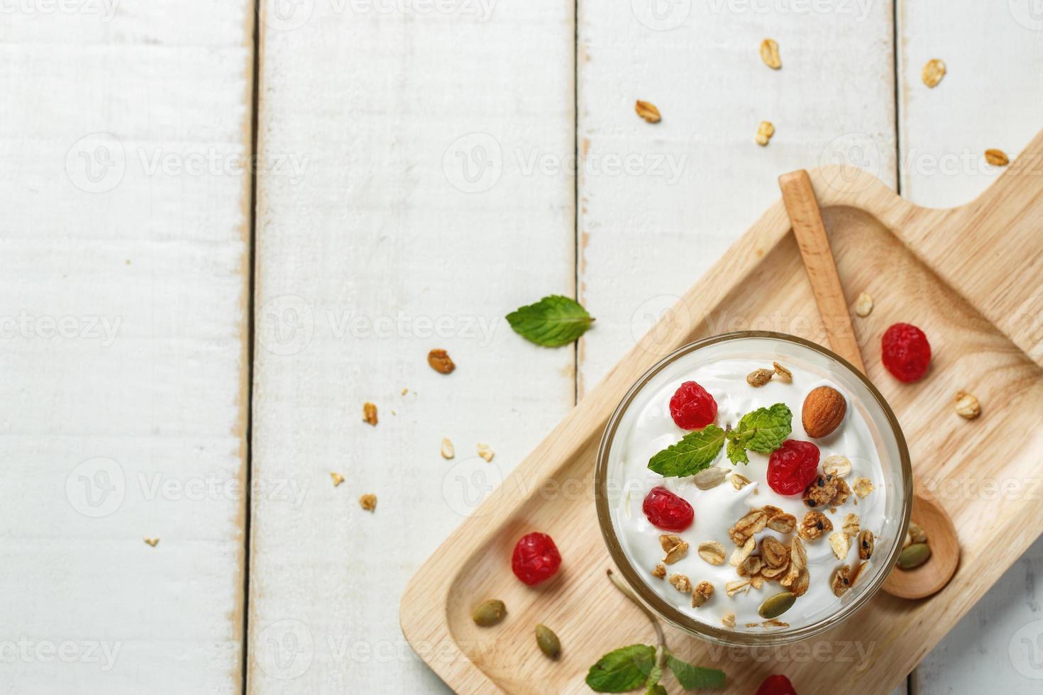 fatti in casa Yogurt o acida crema nel un' bicchiere su il bianca di legno tavolo foto