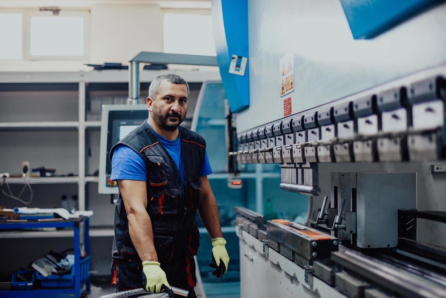 un operaio o un ingegnere intelligente realizza macchine in un'officina di produzione. il concetto di industria e ingegneria. messa a fuoco selettiva foto