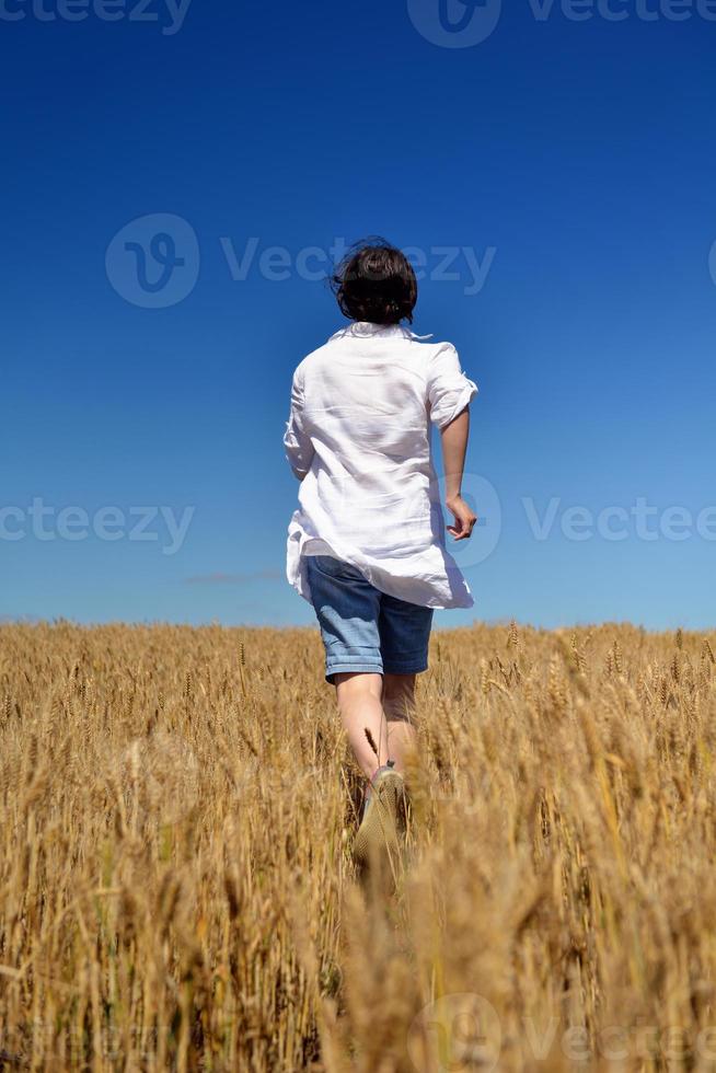 giovane donna nel campo di grano in estate foto