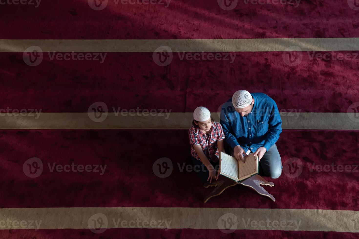 musulmano preghiera padre e figlio nel moschea preghiere e lettura agrifoglio libro Corano insieme islamico formazione scolastica concetto foto
