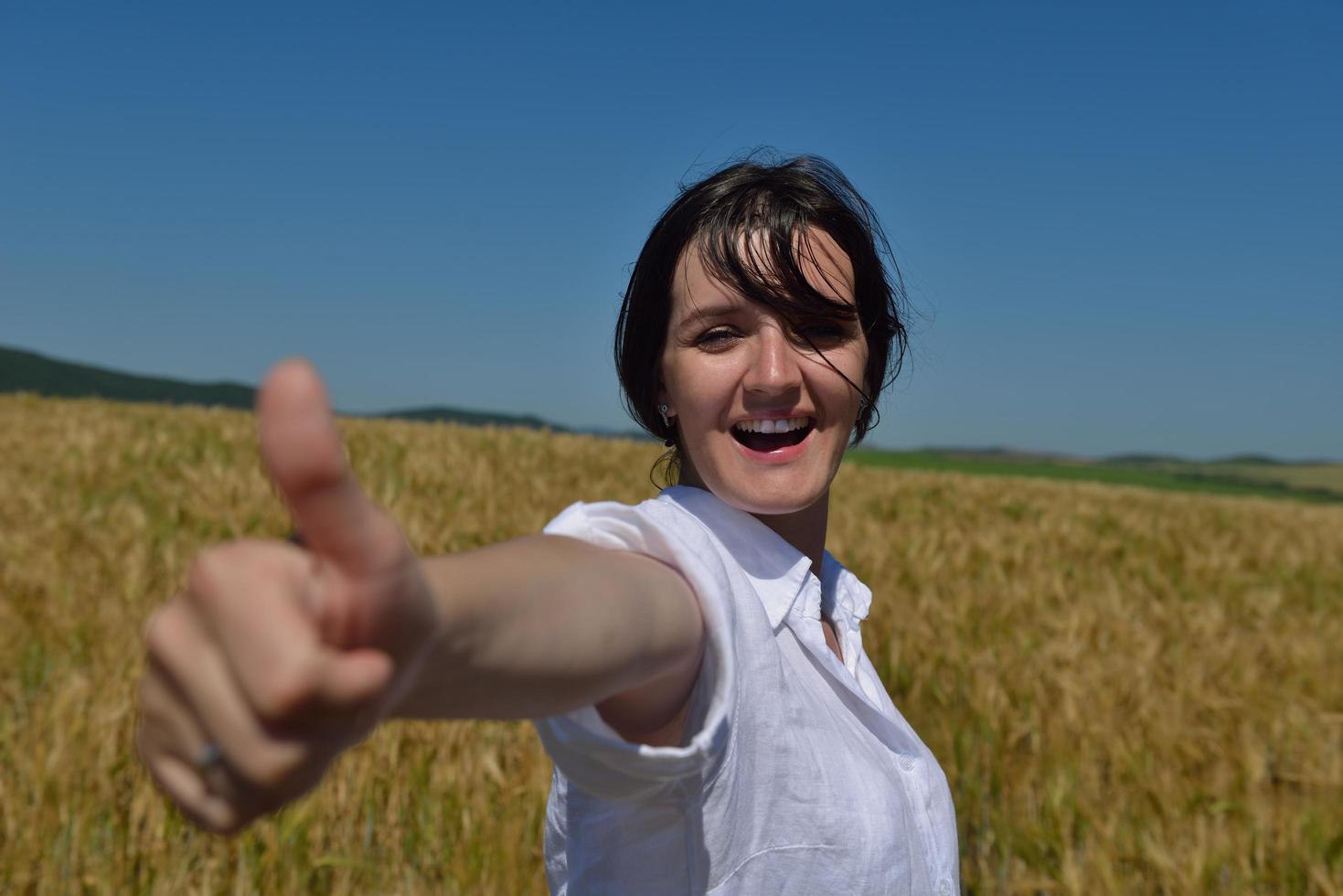 giovane donna nel campo di grano in estate foto