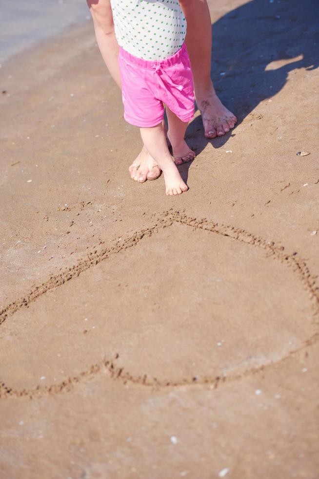 mamma e bambino sulla spiaggia si divertono foto