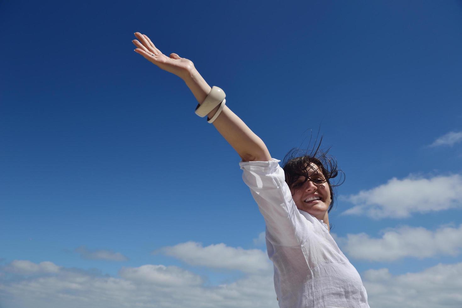 felice giovane donna con le braccia allargate al cielo foto