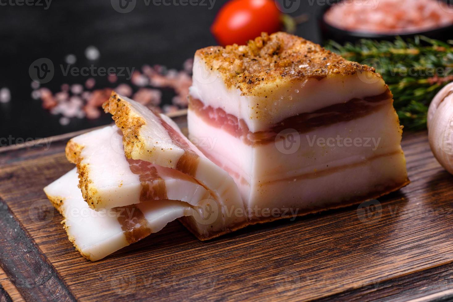 affumicato lardo, Bacon, metà un' pezzo, su un' di legno buio taglio tavola foto
