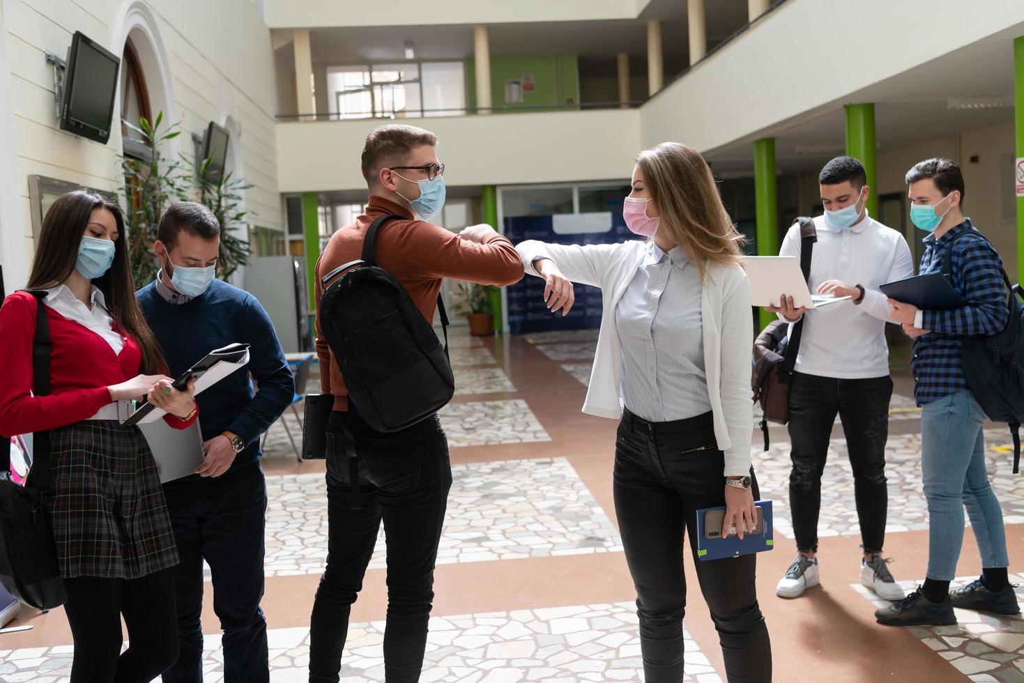 studenti saluto nuovo normale coronavirus stretta di mano e gomito urtando foto