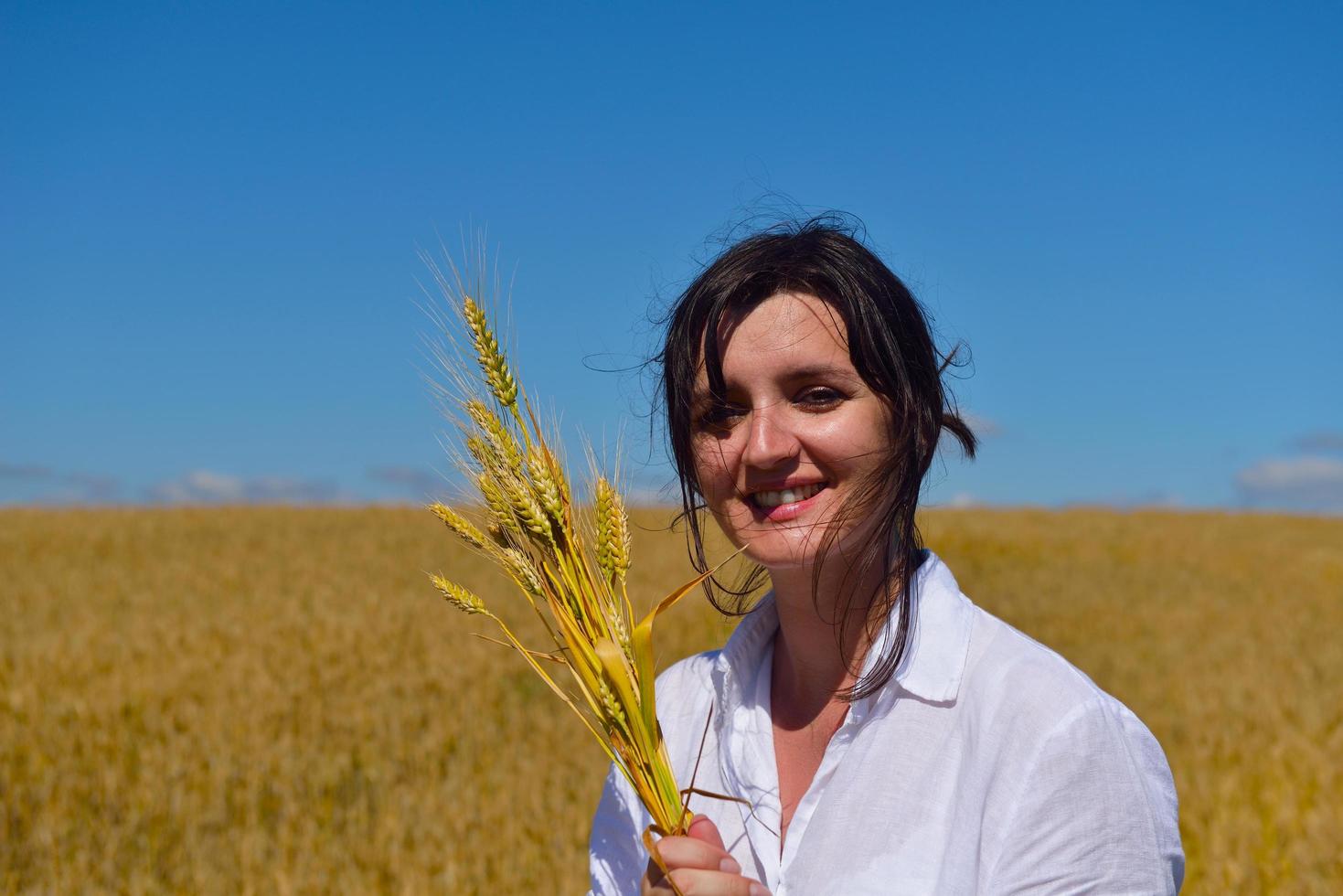 giovane donna nel campo di grano in estate foto