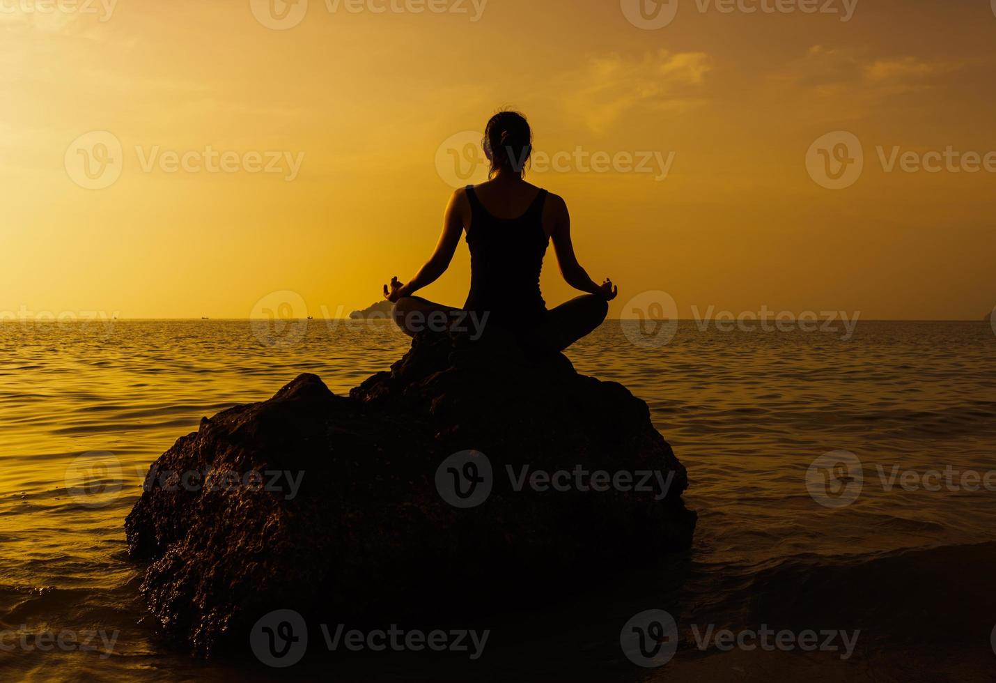 silhouette giovane donna a praticare yoga sulla spiaggia al tramonto. foto