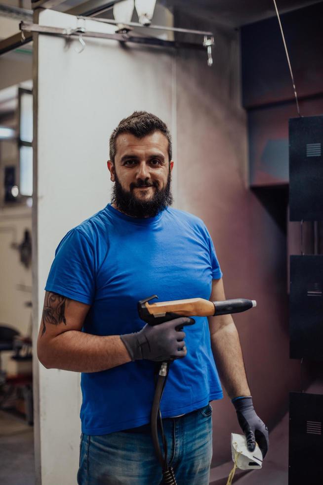 il pittore dipinge l'elemento in ferro. parti di verniciatura industriale. disegni in metallo foto