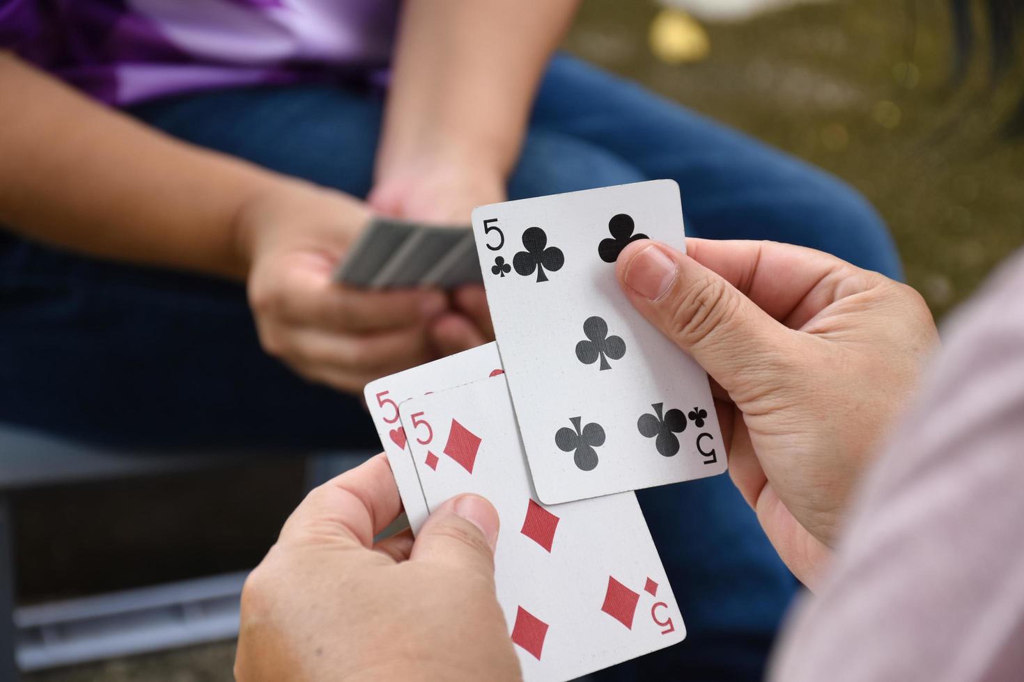 poker carta carte nel mani di donna chi seduta e giocando carta con amico, morbido e selettivo messa a fuoco, tempi liberi e passatempo attività a casa concetto. foto