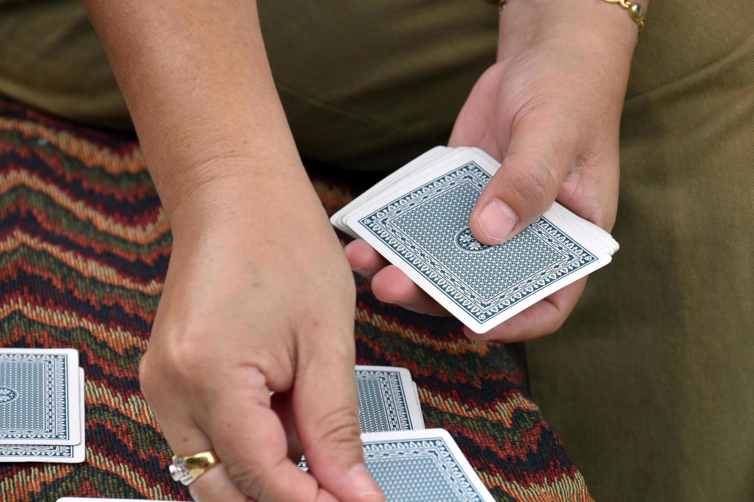 poker carta carte nel mani di donna chi seduta e giocando carta con amico, morbido e selettivo messa a fuoco, tempi liberi e passatempo attività a casa concetto. foto