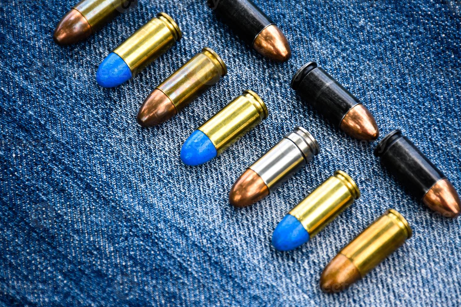 9mm pistola proiettili e proiettile conchiglie su blu jeans, morbido e selettivo messa a fuoco. foto