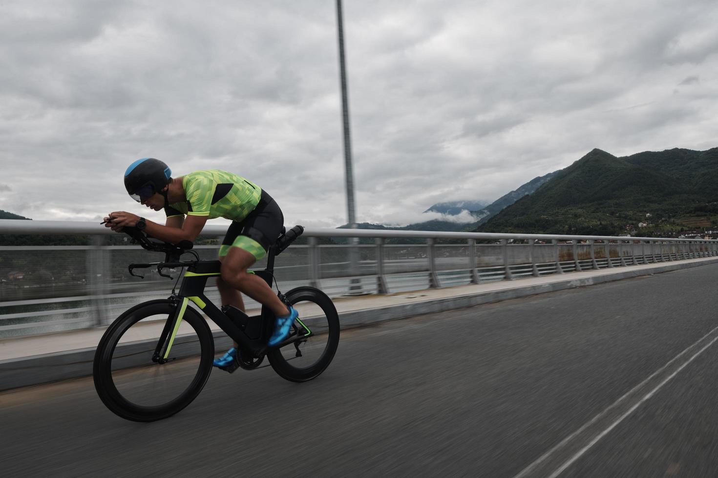 atleta di triathlon in sella a una bicicletta durante l'allenamento mattutino foto