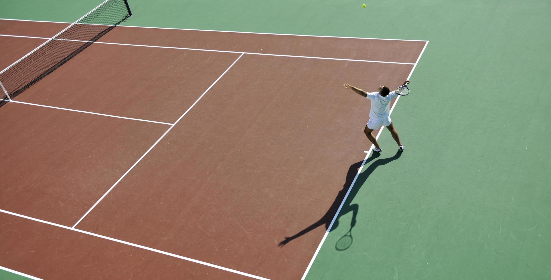 il giovane gioca a tennis foto