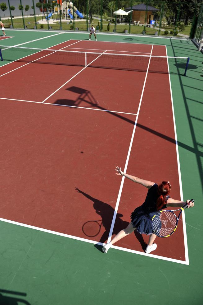 il giovane gioca a tennis all'aperto foto