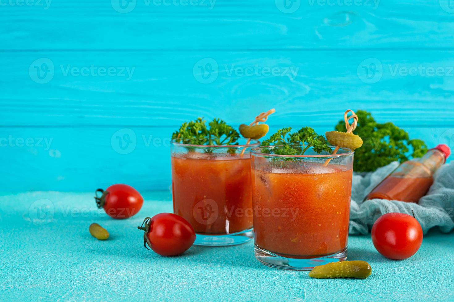 alcool cocktail sanguinoso Maria su blu sfondo. classico cocktail con pomodoro succo e Vodka foto