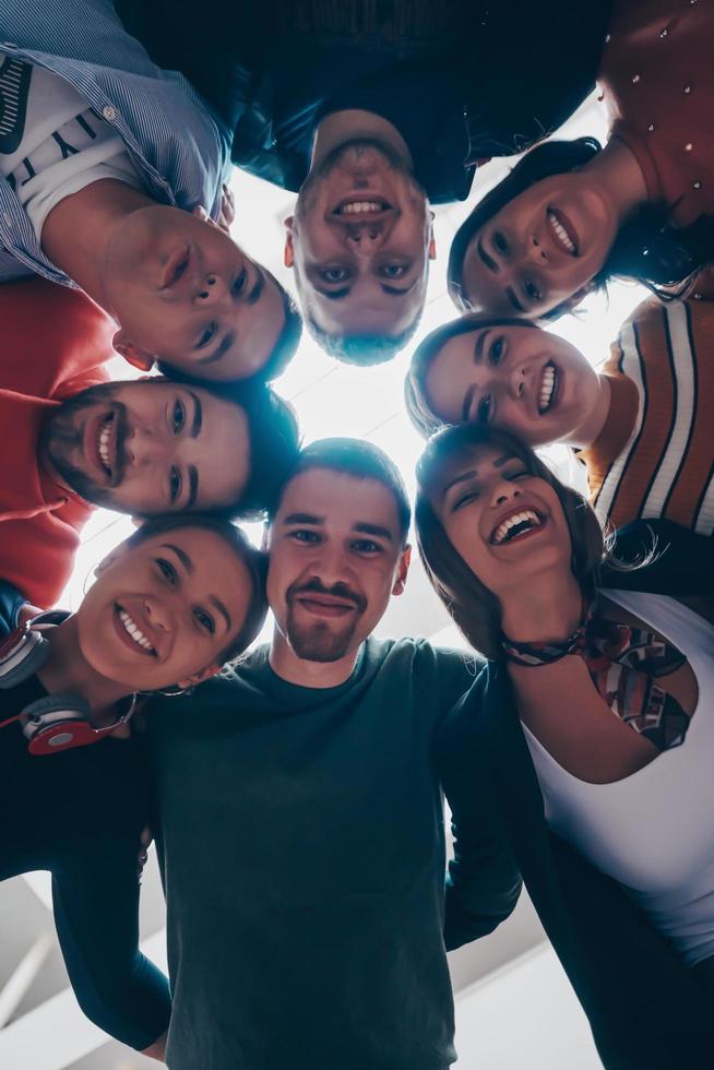 gruppo di contento giovane persone mostrando loro unità foto