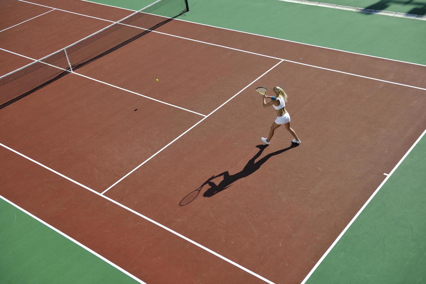 giovane donna giocare a tennis all'aperto foto