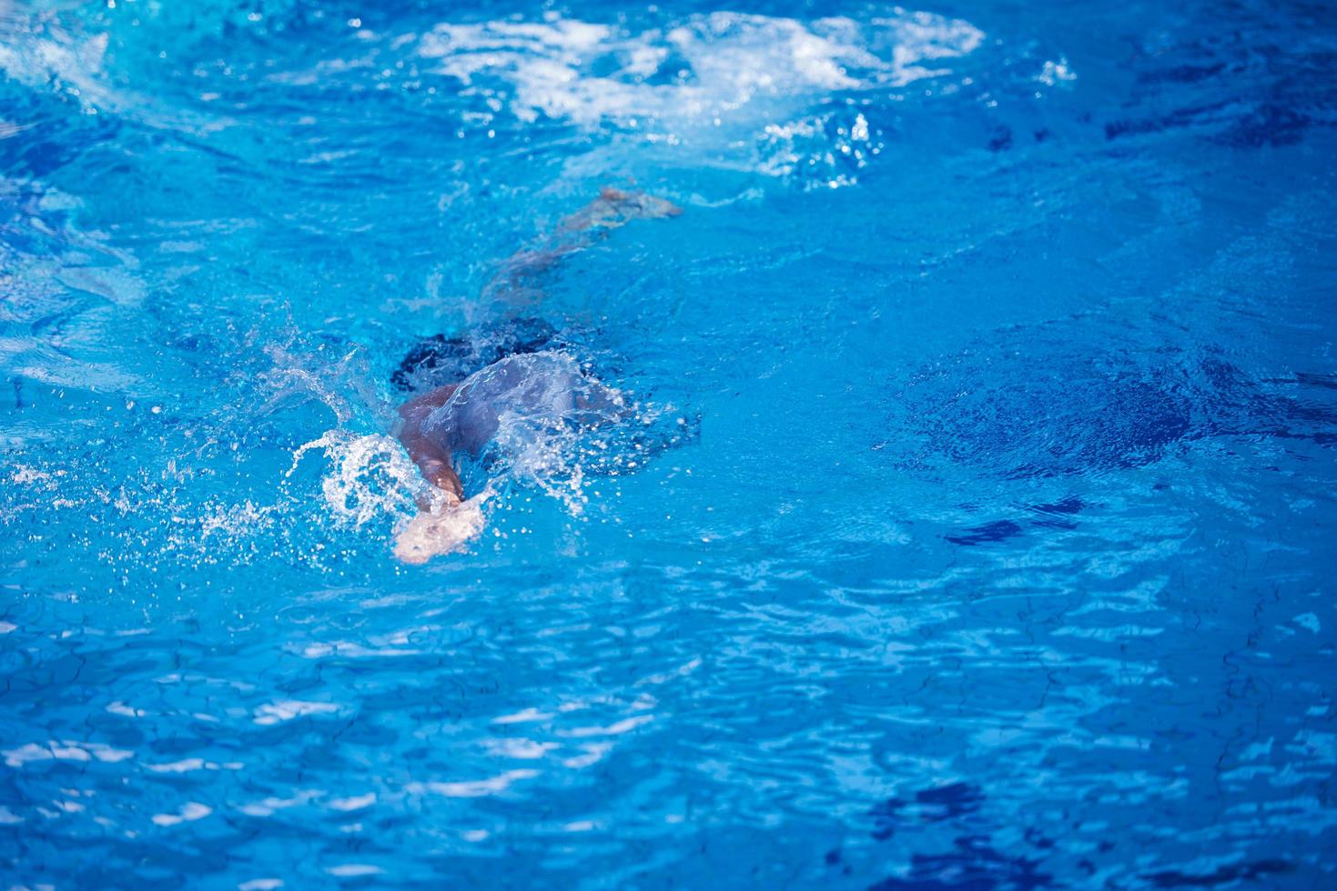 esercizio del nuotatore sulla piscina coperta foto