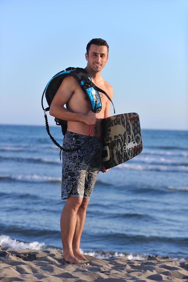 ritratto di un' giovane kitesurf uomo a spiaggia su tramonto foto