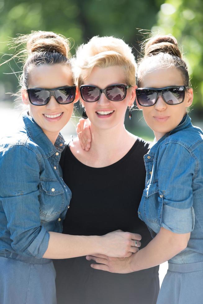 ritratto di tre giovane bellissimo donna con occhiali da sole foto