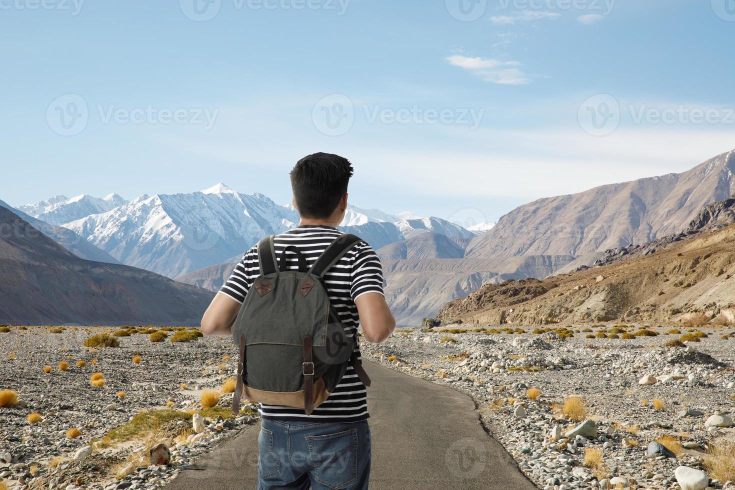 fricchettone giovane asiatico uomo su il strada con zaino e godere il bellezza di paesaggio, avventura e viaggio nel il concetto, in viaggio giro nel Asia leh ladakh, India foto