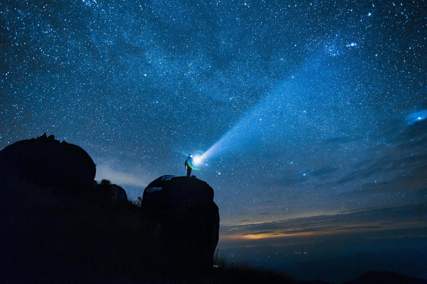 giovane gruppo di turisti godendo nel il campeggio a notte, avendo un' riposo vicino fuoco di bivacco e colorato tenda sotto bellissimo notte cielo pieno di stelle e latteo modo foto