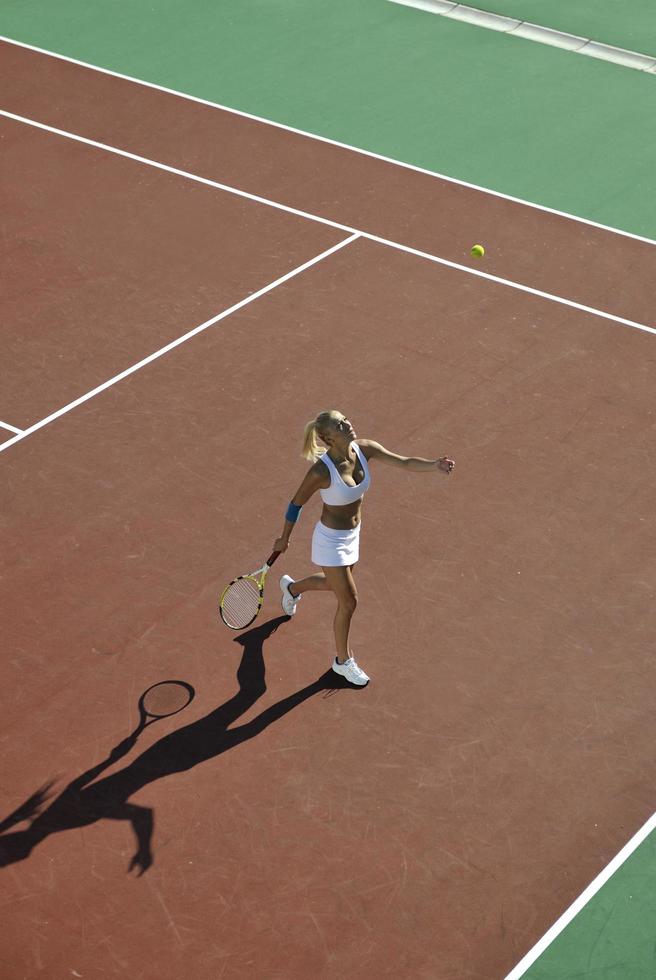 giovane donna giocare a tennis all'aperto foto