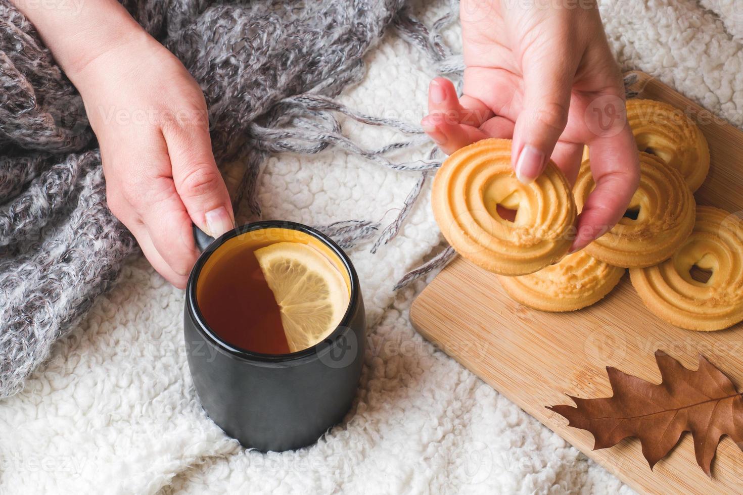 autunno ancora vita con tazza di Tè, biscotti, maglione e le foglie su un' caldo morbido lenzuolo. concetto di accogliente autunno, autunno stagione foto