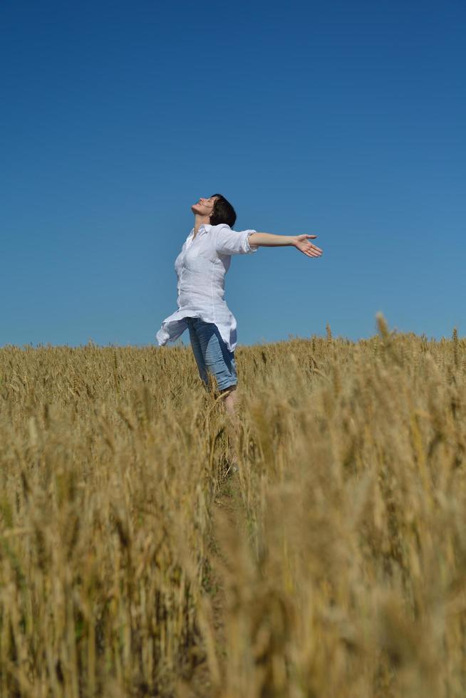 giovane donna nel campo di grano in estate foto