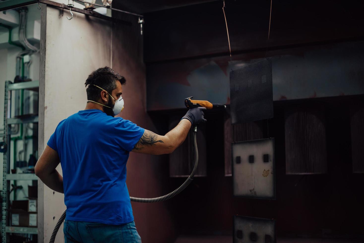 il pittore dipinge l'elemento in ferro. parti di verniciatura industriale. disegni in metallo foto