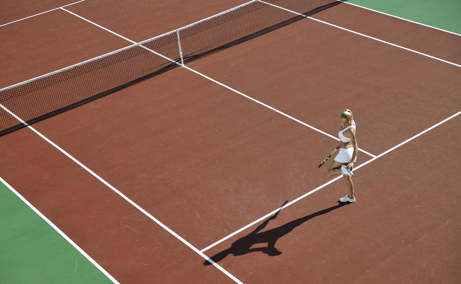 giovane donna giocare a tennis all'aperto foto