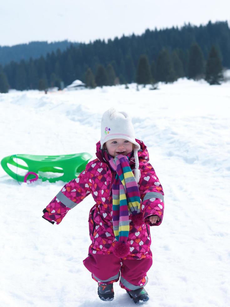 poco bambino ragazza avere divertimento su fresco neve foto