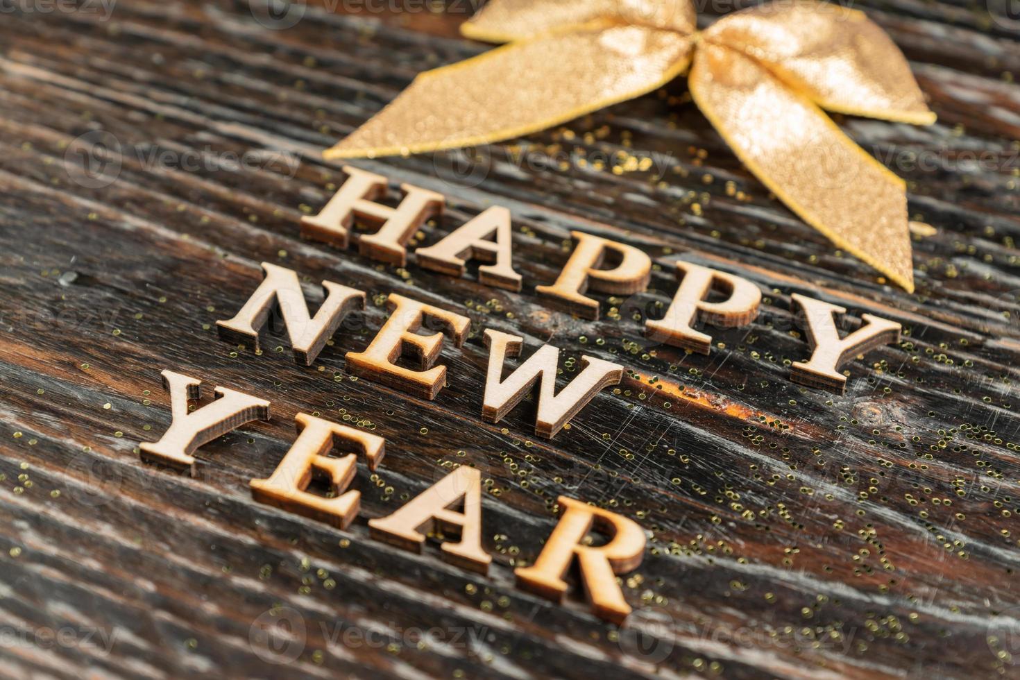 felice nuovo anno iscrizione fatto di di legno lettere con d'oro arco. celebrazione concetto. festivo sfondo foto