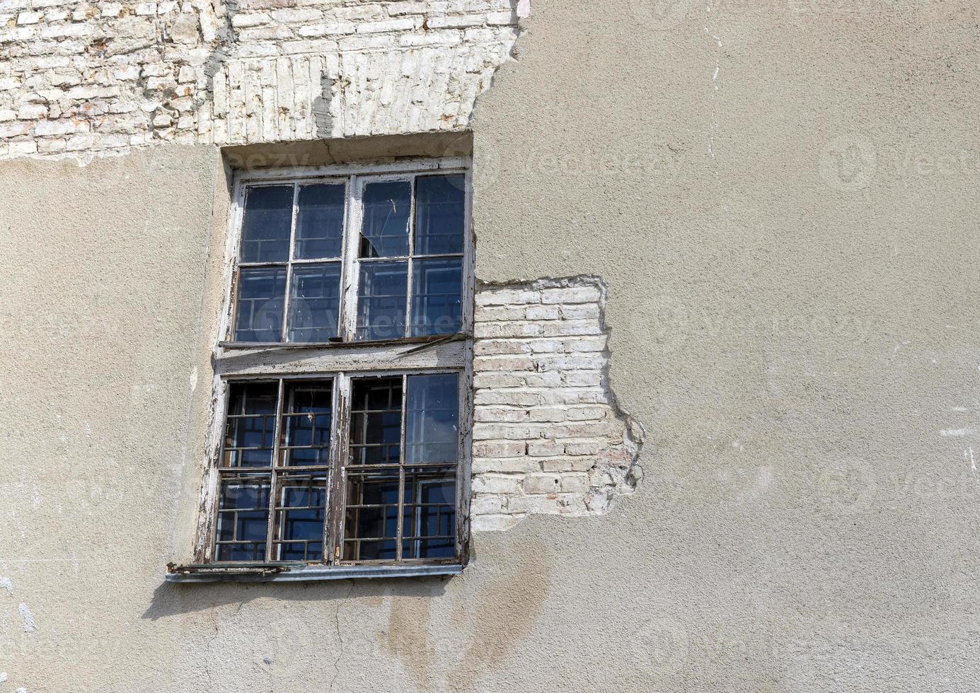 parte di il parete di un vecchio edificio con danneggiato gesso foto