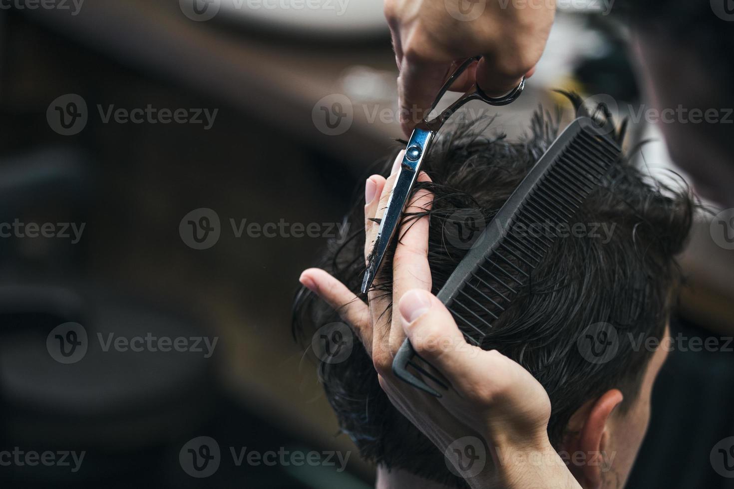 barbiere. avvicinamento di uomo taglio di capelli, maestro fa il capelli messa in piega nel barbiere negozio. avvicinamento, maestro barbiere fa il acconciatura e messa in piega con forbici. concetto barbiere. foto