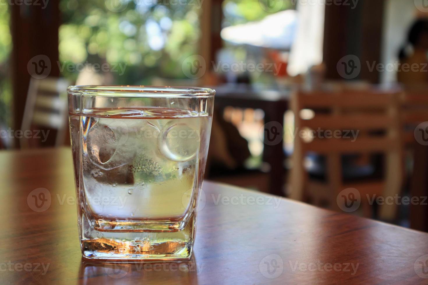 bicchiere d'acqua sul tavolo di legno nel ristorante foto