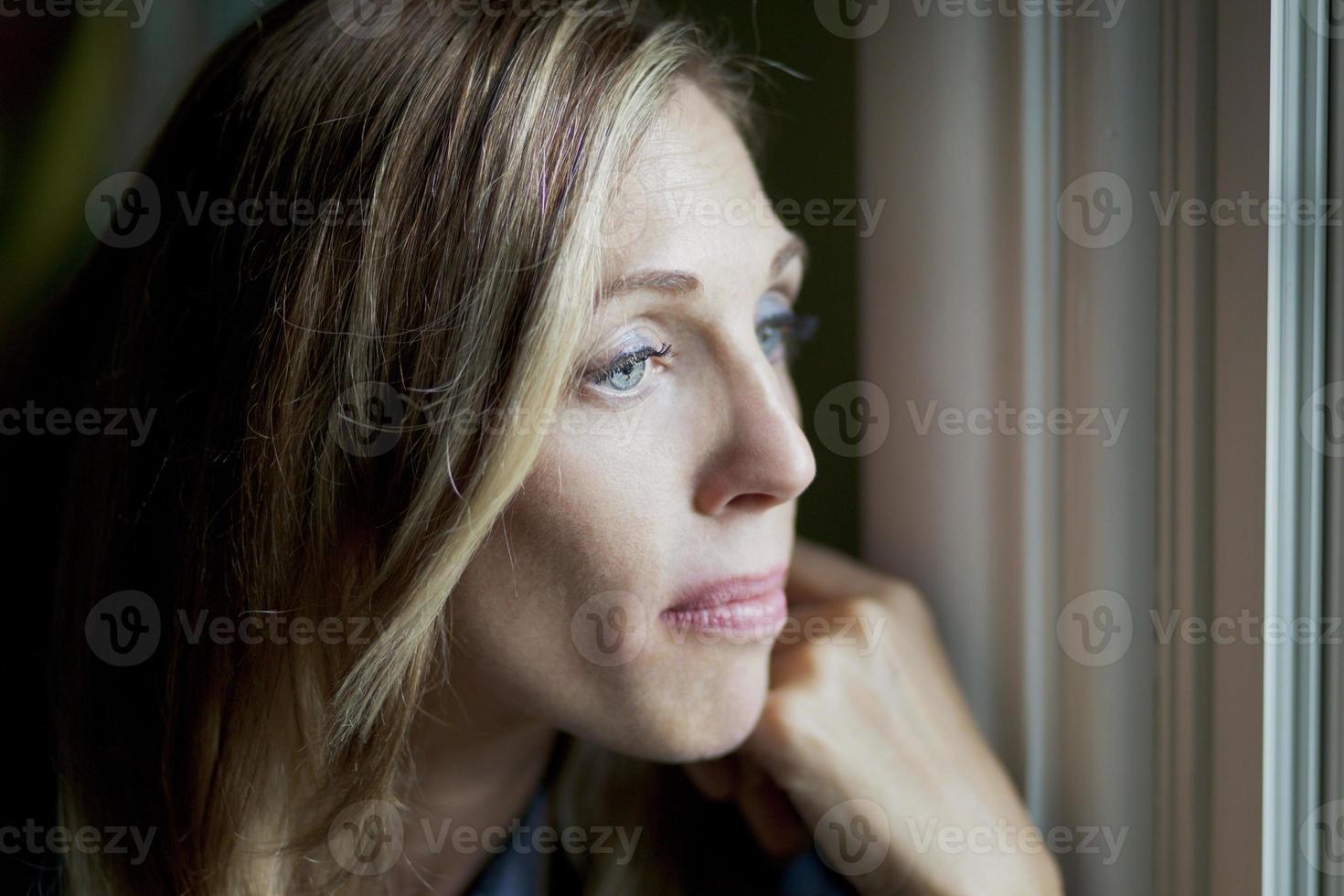 donna triste alla finestra foto