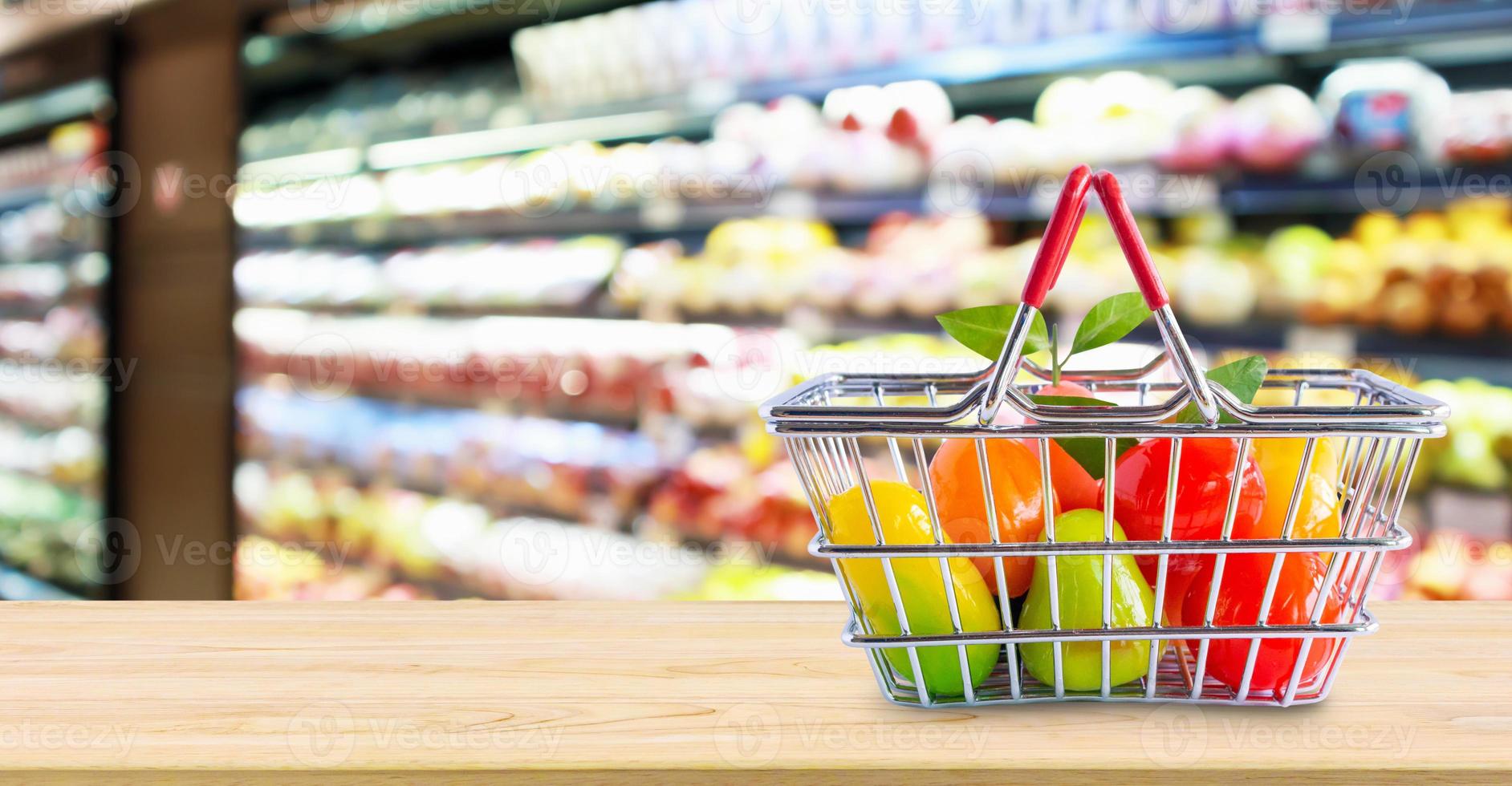 shopping cestino con frutta su legna tavolo al di sopra di drogheria memorizzare supermercato sfocatura sfondo foto