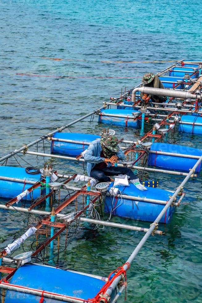 gli operai si sistemano e installano la macchina della fontana dell'acquedotto sulla superficie del mare. foto